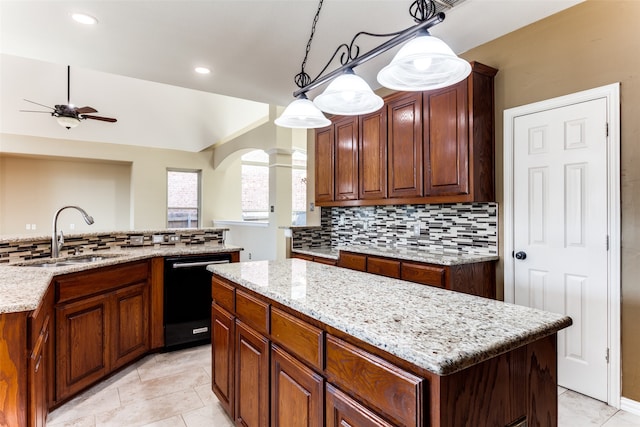 kitchen featuring tasteful backsplash, black dishwasher, a kitchen island, decorative light fixtures, and sink