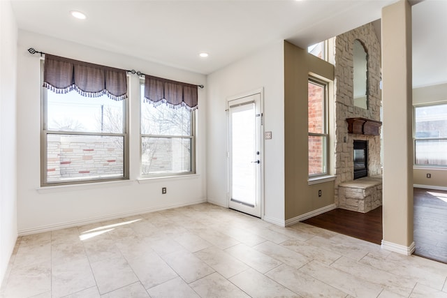 foyer featuring a wealth of natural light and a fireplace