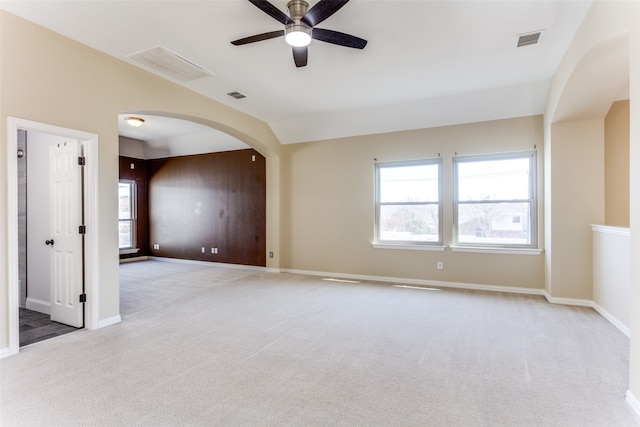 spare room featuring ceiling fan, light carpet, and a wealth of natural light