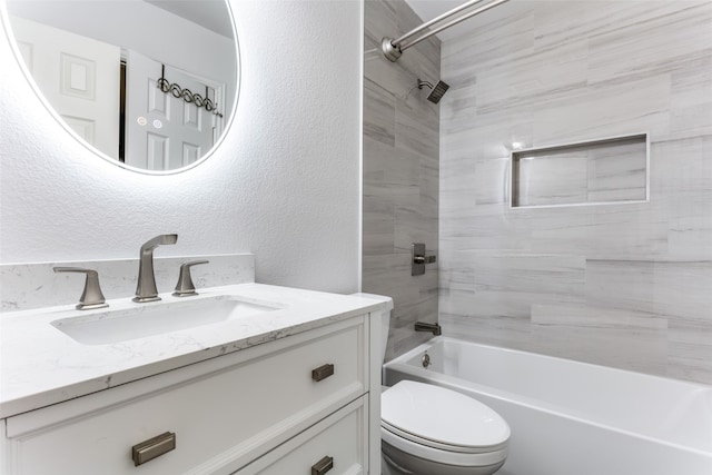 full bathroom with vanity, tiled shower / bath combo, and toilet