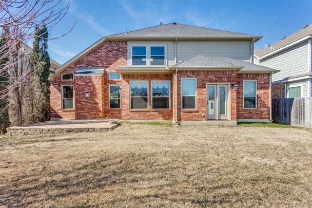 rear view of property featuring a lawn and a patio