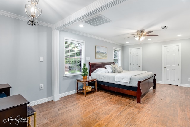 bedroom with ceiling fan with notable chandelier, light hardwood / wood-style floors, and crown molding