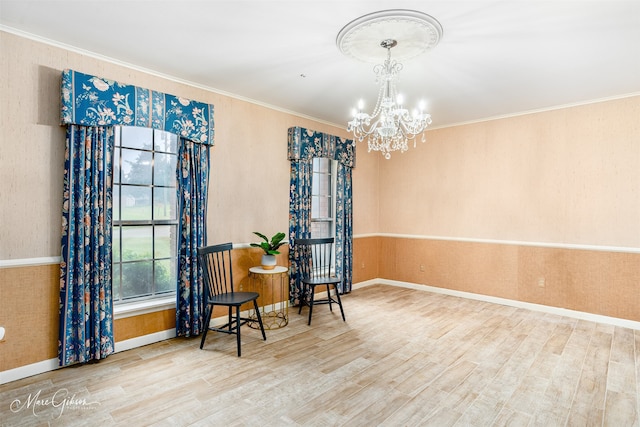 living area featuring crown molding, hardwood / wood-style flooring, and a chandelier