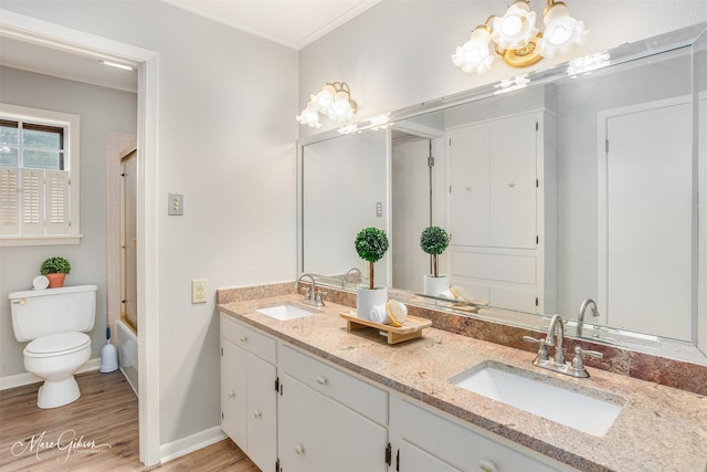 full bathroom featuring toilet, wood-type flooring, enclosed tub / shower combo, ornamental molding, and an inviting chandelier