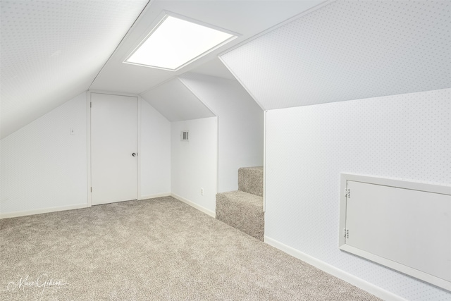 additional living space featuring lofted ceiling and light colored carpet