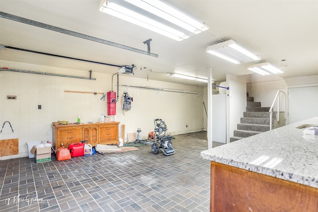 garage with a garage door opener and wooden walls