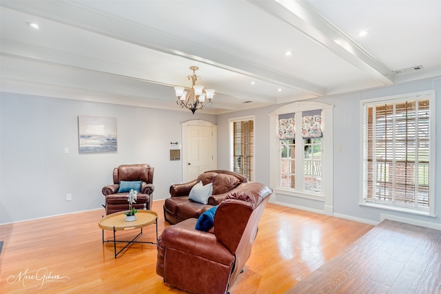 living room featuring light wood-type flooring, an inviting chandelier, and beam ceiling