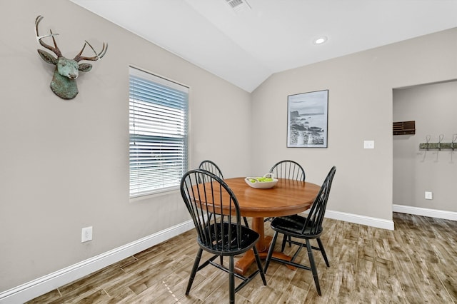 dining area with hardwood / wood-style flooring and lofted ceiling