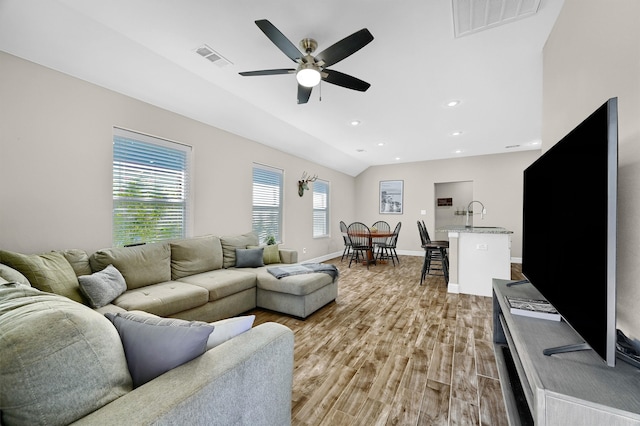 living room featuring ceiling fan, sink, and light hardwood / wood-style floors