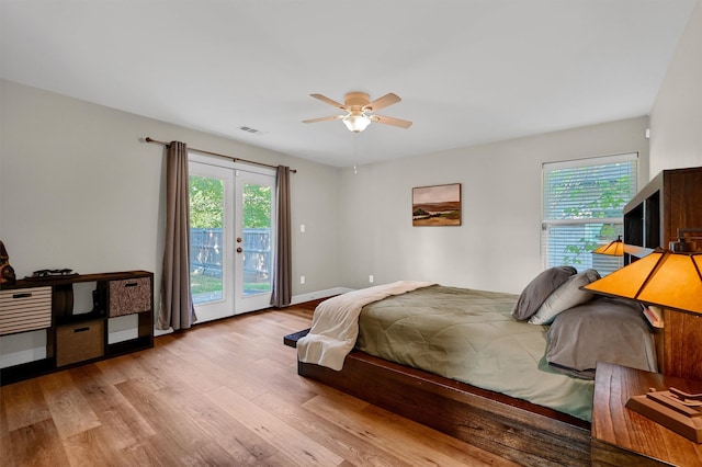 bedroom with light hardwood / wood-style flooring, ceiling fan, multiple windows, and access to exterior