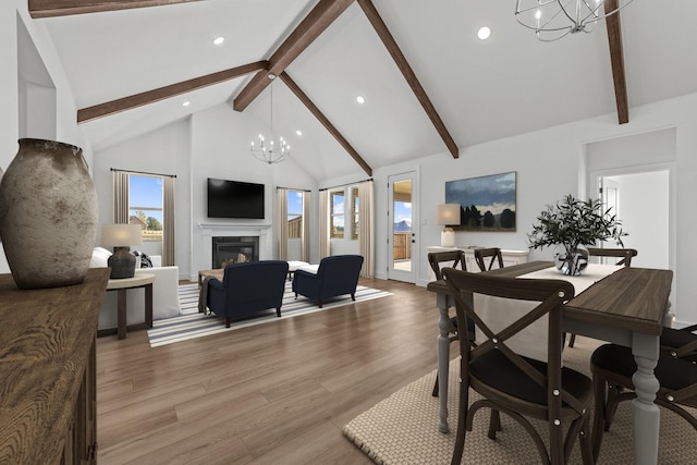 dining area with beamed ceiling, high vaulted ceiling, wood-type flooring, and a notable chandelier