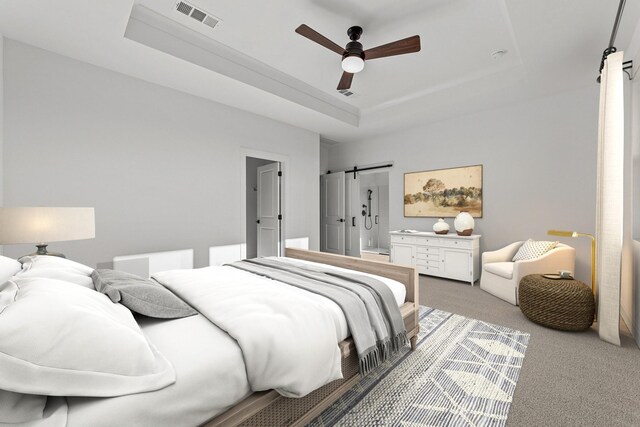 bedroom with ceiling fan, a barn door, light carpet, and a tray ceiling