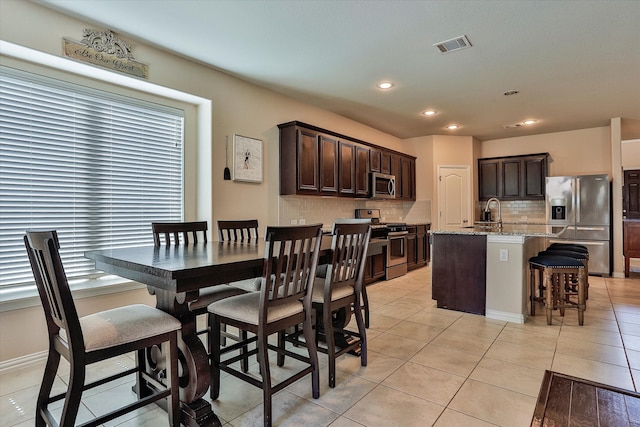 tiled dining room with sink and a healthy amount of sunlight