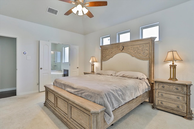 carpeted bedroom with ensuite bathroom and ceiling fan