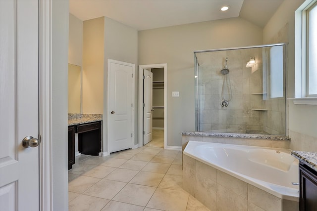 bathroom featuring plus walk in shower, vanity, and tile patterned flooring