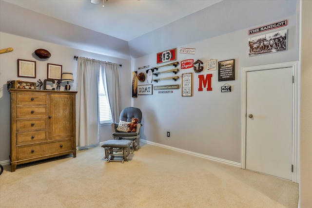 living area featuring light carpet and ceiling fan