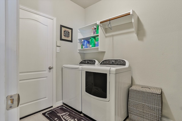 laundry area with light tile patterned floors and washing machine and dryer