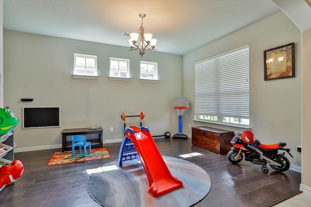 game room with dark hardwood / wood-style floors and a notable chandelier