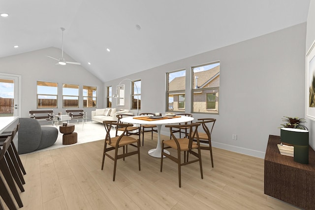 dining area featuring high vaulted ceiling, light wood finished floors, a wealth of natural light, and baseboards