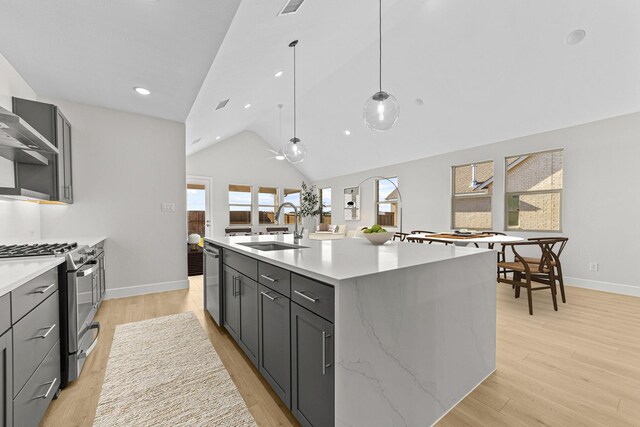 kitchen with stainless steel appliances, gray cabinetry, a sink, and light wood finished floors