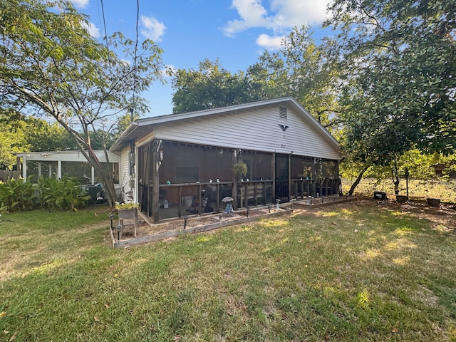 rear view of property with a sunroom and a yard