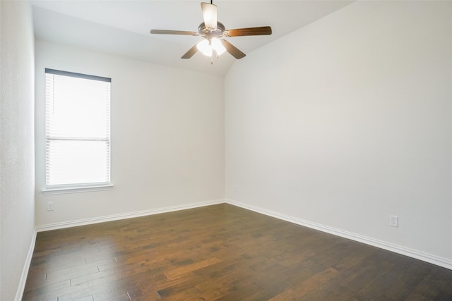 empty room featuring dark hardwood / wood-style floors, vaulted ceiling, and ceiling fan