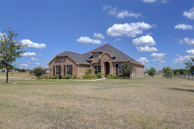 view of front of house featuring a front yard, brick siding, and fence