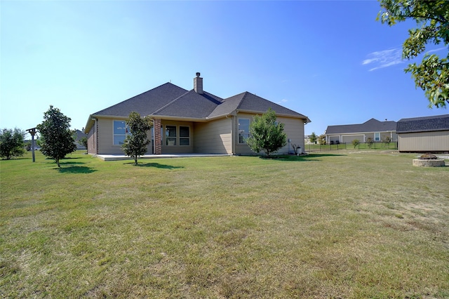 back of house featuring a patio and a yard