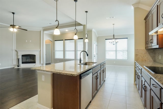 kitchen featuring light wood-type flooring, sink, a center island with sink, decorative light fixtures, and dishwasher