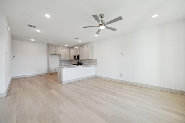 kitchen with kitchen peninsula, decorative backsplash, stainless steel appliances, ceiling fan, and light hardwood / wood-style flooring