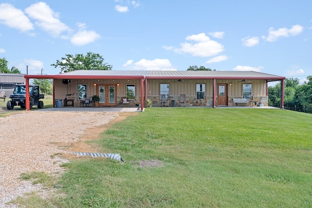 view of front of house featuring french doors, dirt driveway, board and batten siding, stone siding, and a front lawn