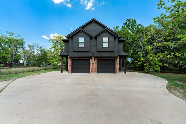 view of home's exterior with a garage, concrete driveway, brick siding, and fence