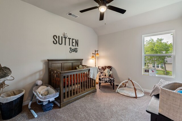 bedroom with carpet floors, vaulted ceiling, a nursery area, and ceiling fan