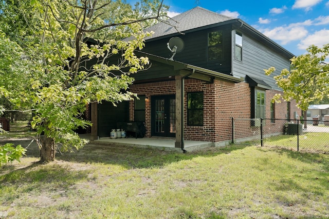 rear view of house with a patio, central AC, and a yard