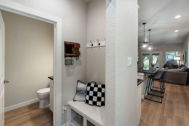 mudroom with a textured wall, recessed lighting, wood finished floors, baseboards, and french doors