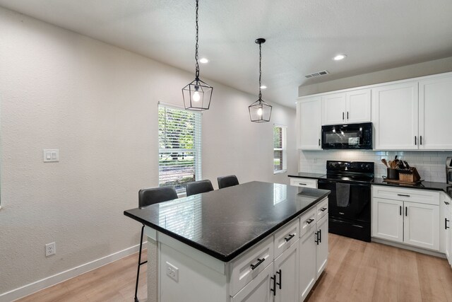 kitchen with a center island, backsplash, black appliances, and light hardwood / wood-style floors