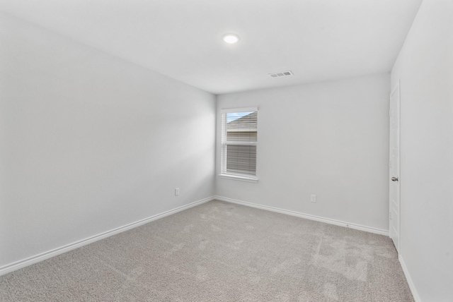 carpeted empty room featuring baseboards and visible vents