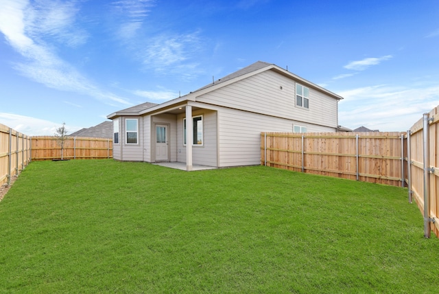 rear view of property featuring a patio area and a yard