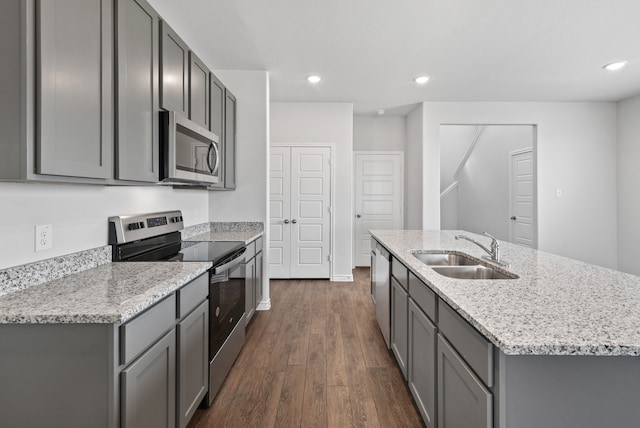 kitchen featuring sink, dark hardwood / wood-style flooring, appliances with stainless steel finishes, light stone countertops, and gray cabinetry