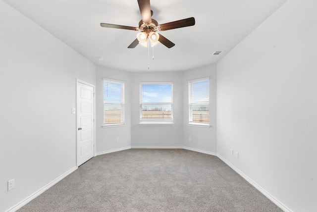 spare room featuring ceiling fan, carpet floors, and a wealth of natural light