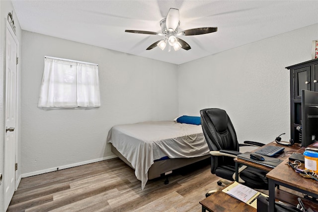 bedroom featuring baseboards, a ceiling fan, and wood finished floors