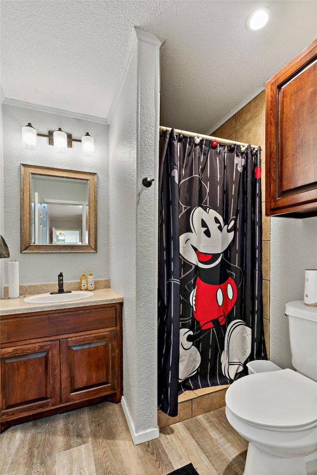 full bath featuring a textured wall, toilet, ornamental molding, wood finished floors, and a textured ceiling