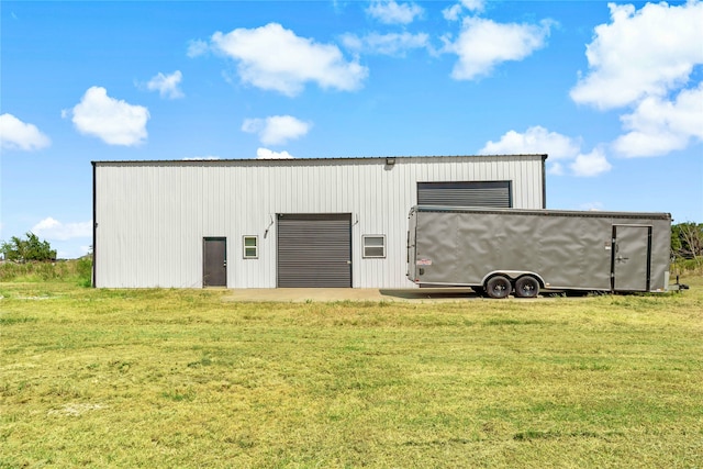 view of outdoor structure featuring a lawn and a garage