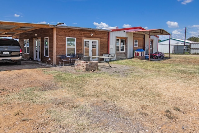 rear view of property featuring french doors and a lawn