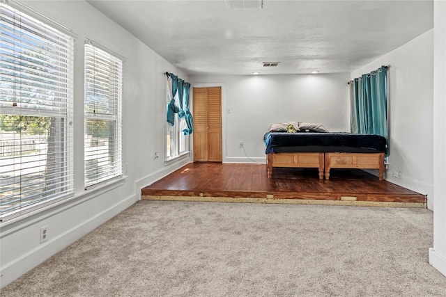 carpeted bedroom with visible vents and baseboards