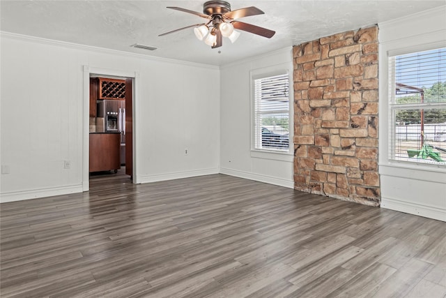 unfurnished room featuring a ceiling fan, a healthy amount of sunlight, ornamental molding, and dark wood-style flooring