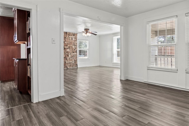 unfurnished room featuring baseboards, a ceiling fan, and wood finished floors