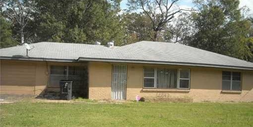 rear view of house featuring a lawn