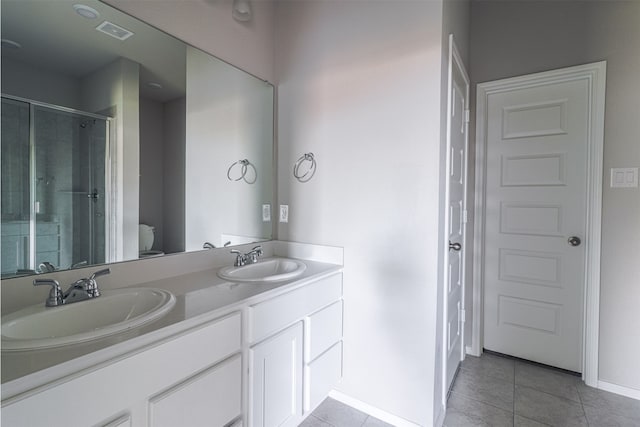 bathroom featuring tile patterned floors, double sink vanity, and toilet