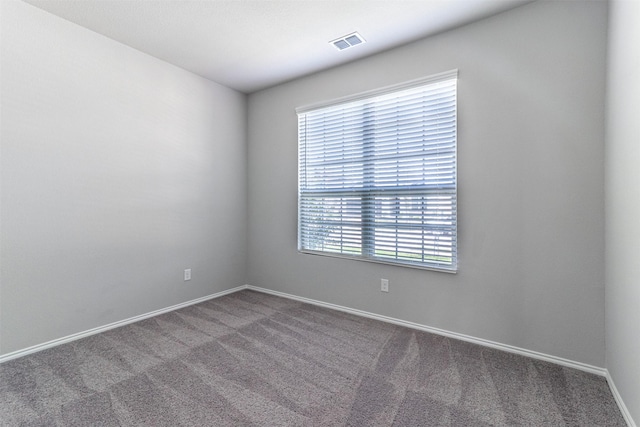 unfurnished room featuring visible vents, carpet floors, and baseboards